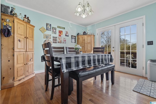 dining area featuring french doors, an inviting chandelier, crown molding, and hardwood / wood-style floors