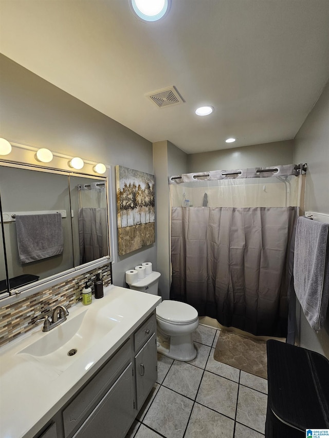 bathroom with tile patterned floors, vanity, toilet, and decorative backsplash