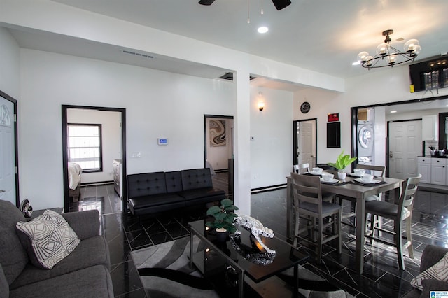 living room with ceiling fan with notable chandelier