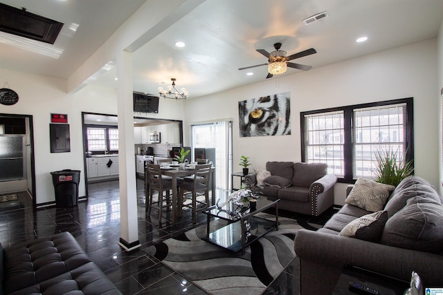 living room featuring electric panel and ceiling fan with notable chandelier