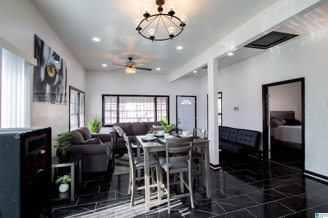 dining space with ceiling fan with notable chandelier