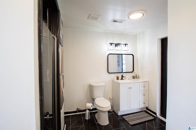 bathroom with vanity, tile patterned floors, toilet, and walk in shower