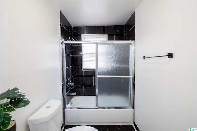 bathroom with shower / bath combination with glass door and toilet