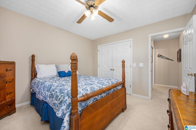 bedroom with light colored carpet, ceiling fan, and a closet