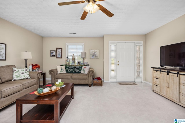 carpeted living room with a textured ceiling and ceiling fan