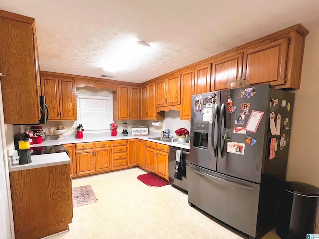 kitchen featuring sink, stainless steel appliances, and a textured ceiling