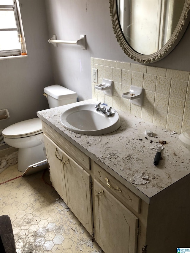 bathroom featuring tasteful backsplash, vanity, and toilet