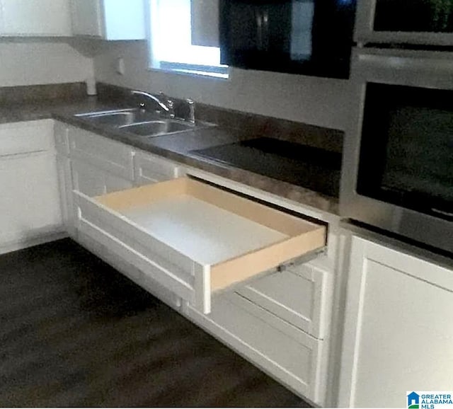 kitchen with white cabinetry, sink, stainless steel oven, and black electric stovetop