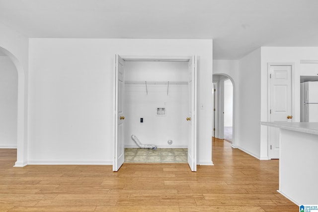 clothes washing area with light hardwood / wood-style floors