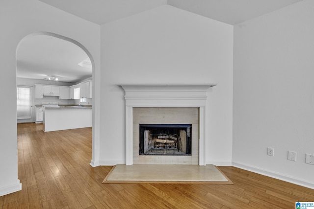 interior details with hardwood / wood-style flooring and a tiled fireplace