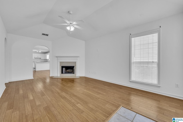 unfurnished living room featuring vaulted ceiling, ceiling fan, and light hardwood / wood-style flooring