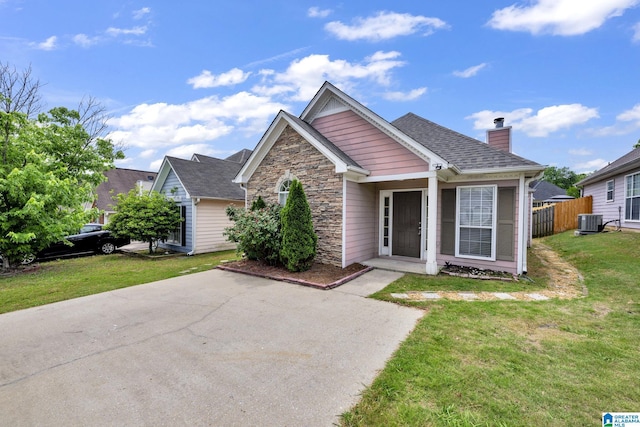 view of front of property featuring cooling unit and a front yard