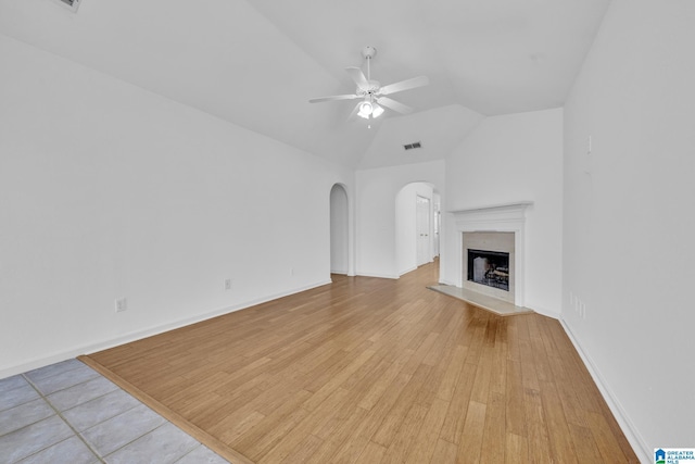 unfurnished living room featuring vaulted ceiling, ceiling fan, and light hardwood / wood-style floors