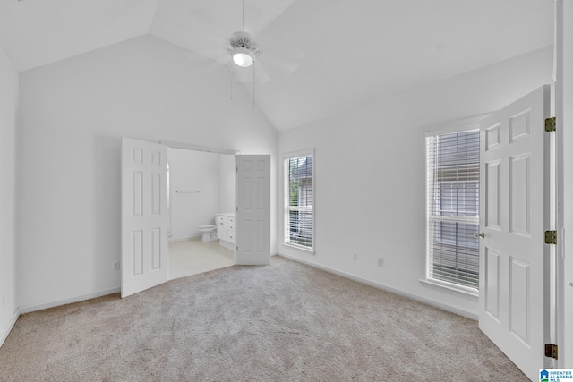 unfurnished bedroom with light carpet, high vaulted ceiling, ceiling fan, and ensuite bathroom