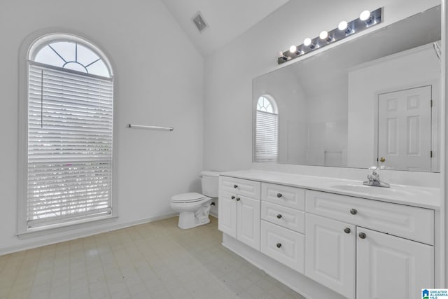 bathroom with vanity, toilet, and vaulted ceiling