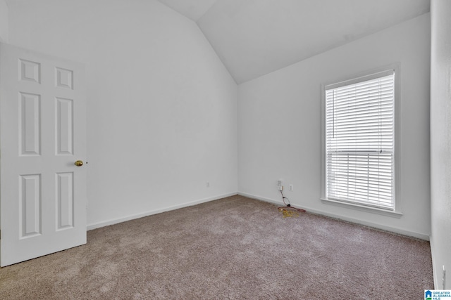 unfurnished room with light colored carpet and lofted ceiling