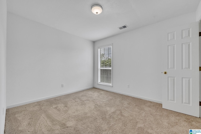 spare room featuring light colored carpet