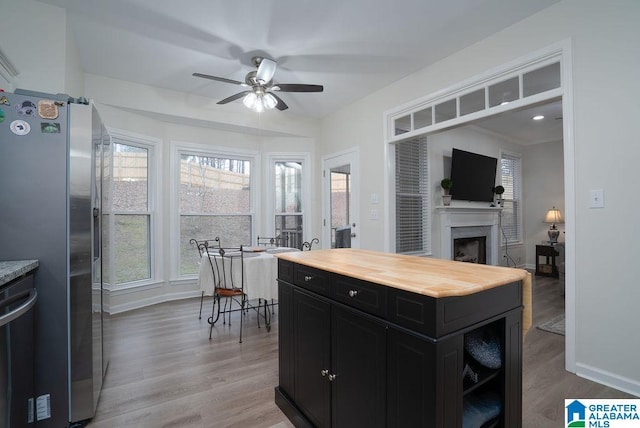 kitchen with wood counters, ceiling fan, stainless steel fridge, and wood-type flooring