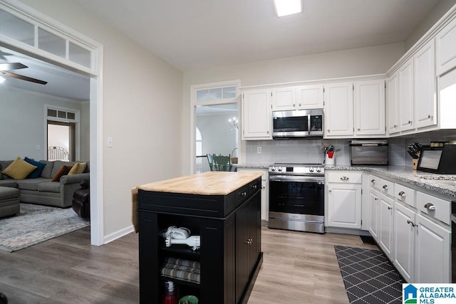 kitchen featuring white cabinetry, decorative backsplash, a center island, light hardwood / wood-style floors, and stainless steel appliances