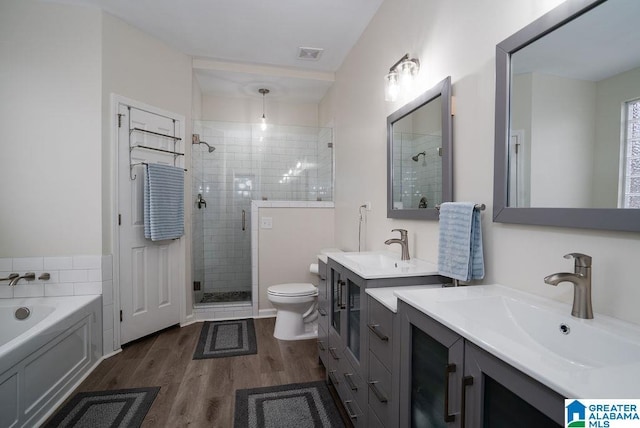 full bathroom with hardwood / wood-style flooring, vanity, separate shower and tub, and toilet