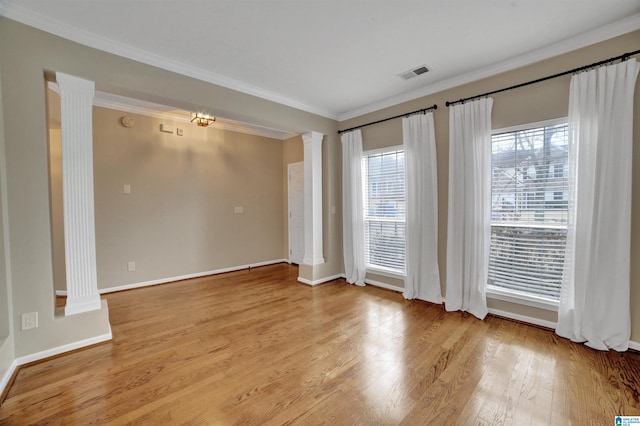 empty room with crown molding, light hardwood / wood-style floors, and ornate columns