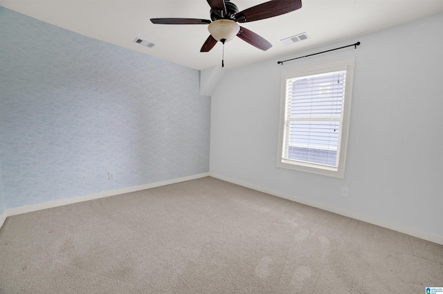 unfurnished room with ceiling fan and carpet