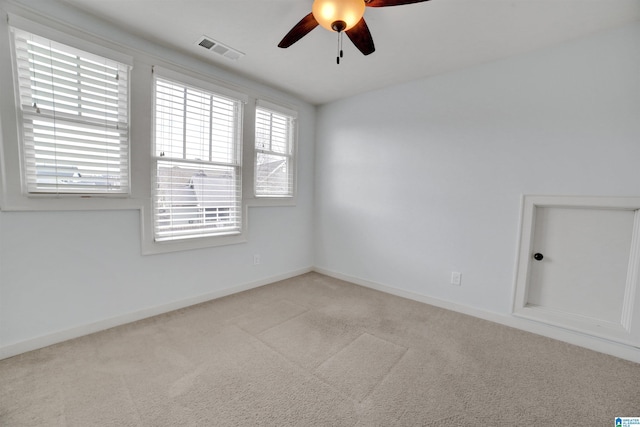 empty room featuring light colored carpet and ceiling fan