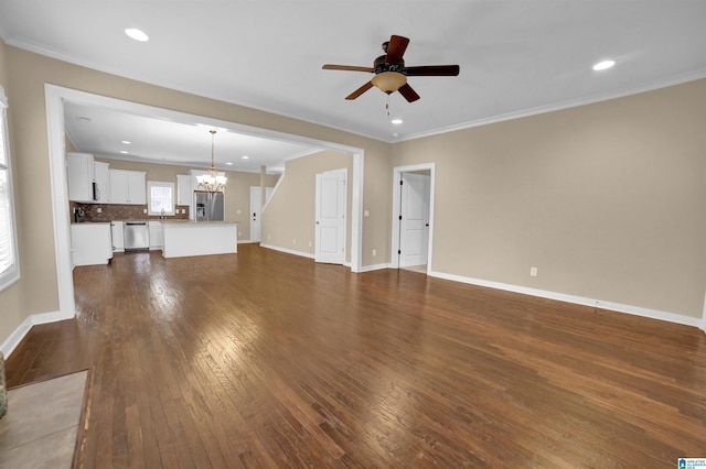 unfurnished living room featuring crown molding, ceiling fan with notable chandelier, and dark hardwood / wood-style floors