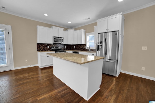 kitchen with stainless steel appliances, white cabinetry, a center island, and sink