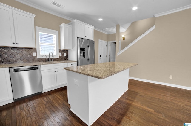 kitchen featuring white cabinetry, appliances with stainless steel finishes, sink, and a kitchen island