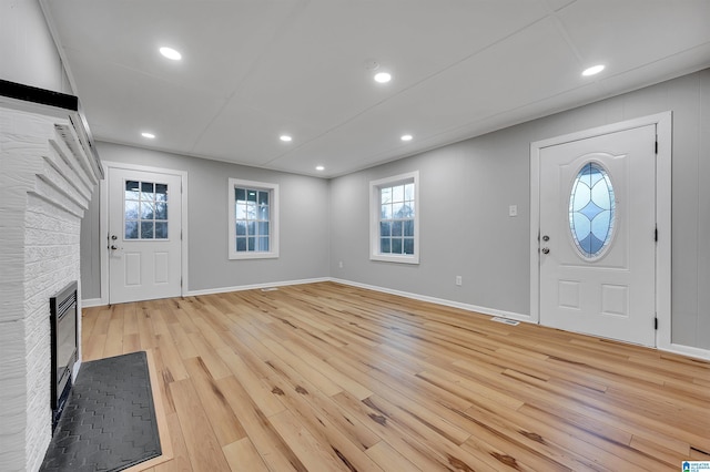 entrance foyer with a fireplace and light hardwood / wood-style floors