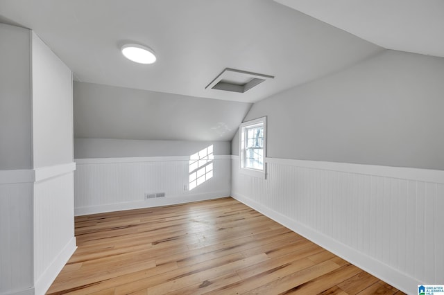 additional living space with lofted ceiling and light wood-type flooring