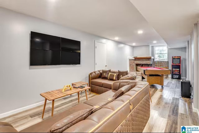 living room featuring a brick fireplace and light hardwood / wood-style flooring