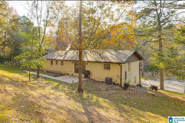 view of property exterior with cooling unit, a yard, and a patio area