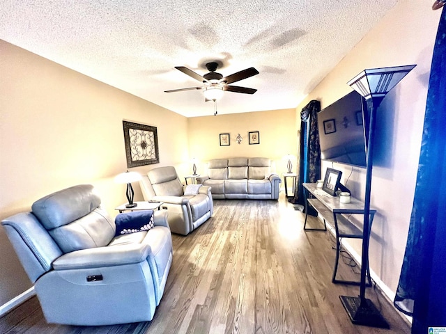 living room featuring hardwood / wood-style flooring, a textured ceiling, and ceiling fan