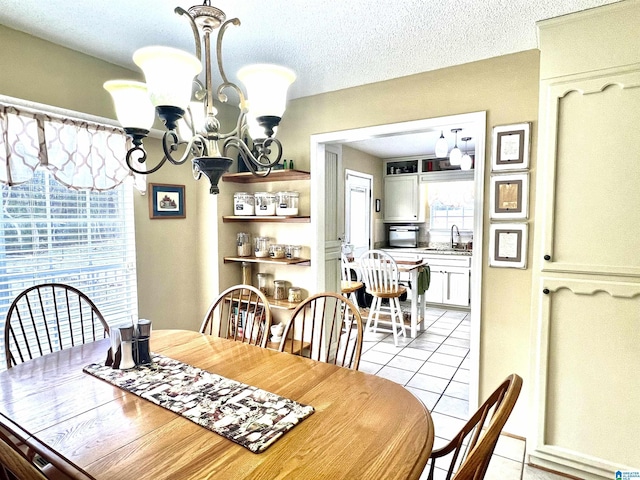 tiled dining area featuring a notable chandelier, sink, and a textured ceiling