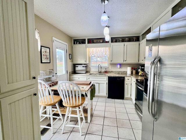 kitchen with sink, white cabinetry, light tile patterned floors, pendant lighting, and stainless steel appliances