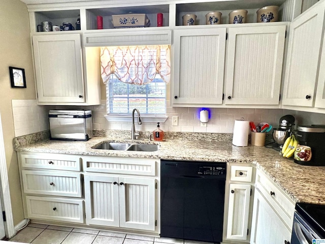 kitchen with sink, black dishwasher, light stone countertops, white cabinets, and decorative backsplash