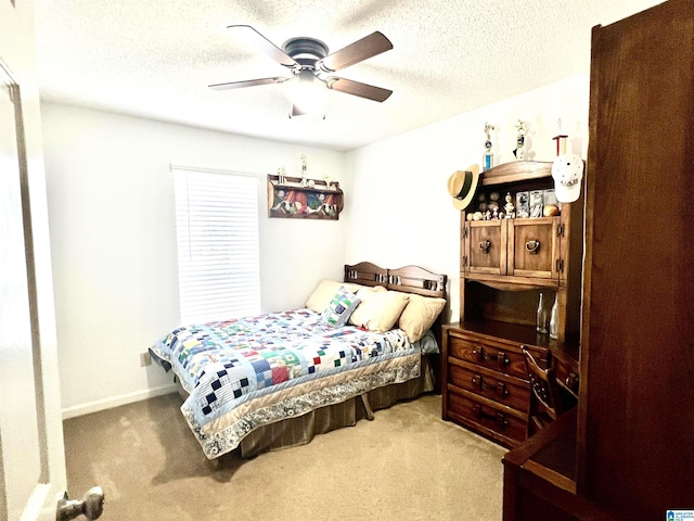 carpeted bedroom featuring ceiling fan and a textured ceiling