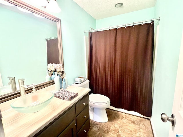 bathroom featuring vanity, toilet, curtained shower, and a textured ceiling