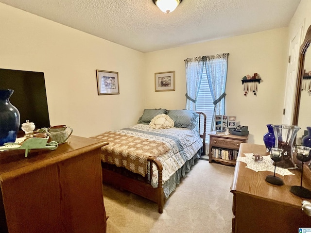 bedroom with light colored carpet and a textured ceiling