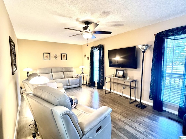 living room featuring ceiling fan, hardwood / wood-style floors, and a textured ceiling