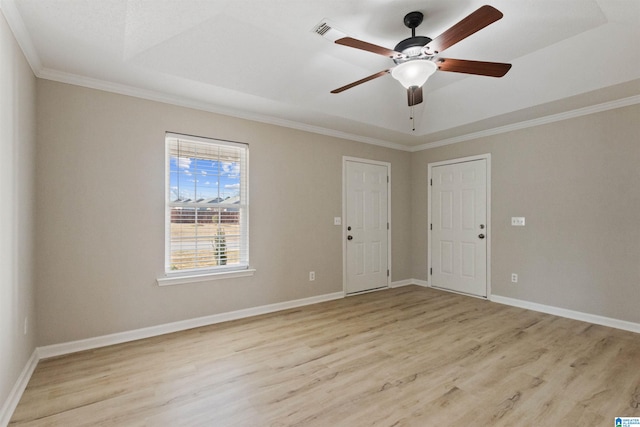 spare room featuring a raised ceiling, ornamental molding, ceiling fan, and light hardwood / wood-style flooring