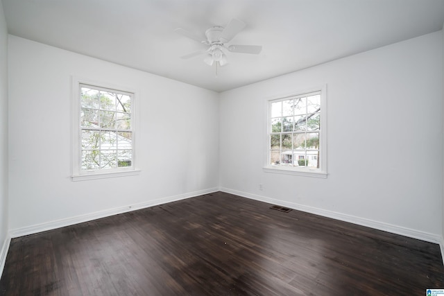 spare room with ceiling fan, dark hardwood / wood-style floors, and a healthy amount of sunlight