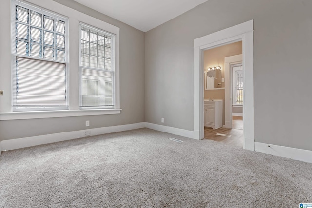 unfurnished room with light colored carpet and a wealth of natural light