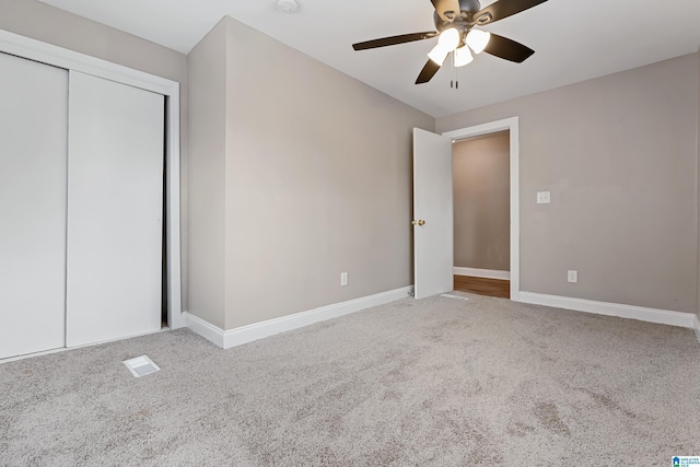 unfurnished bedroom with carpet floors, ceiling fan, and a closet