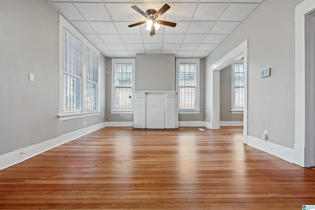 unfurnished living room with a paneled ceiling, light hardwood / wood-style floors, and ceiling fan