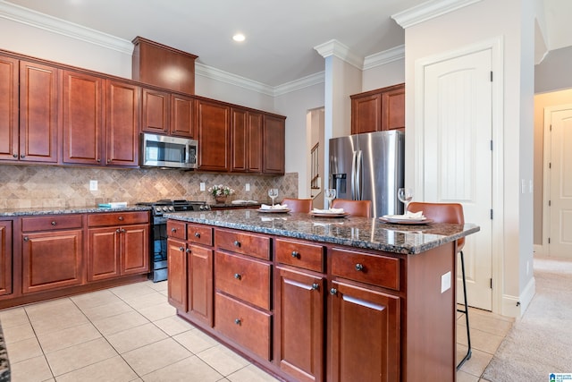 kitchen with a kitchen island, tasteful backsplash, dark stone counters, stainless steel appliances, and crown molding