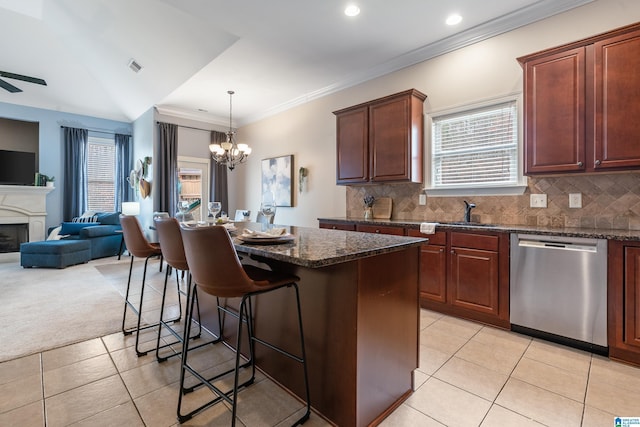 kitchen featuring a kitchen island, pendant lighting, dishwasher, a breakfast bar area, and dark stone countertops