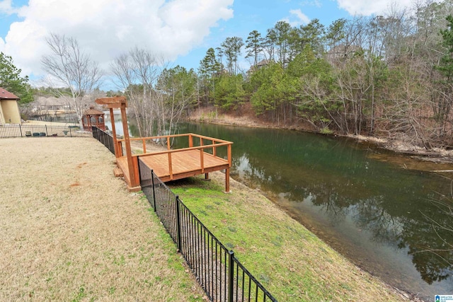 view of dock with a yard and a water view